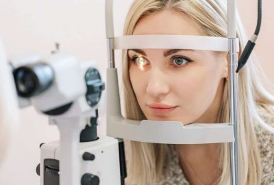 Patient receiving a comprehensive eye exam with an optometrist's slit lamp