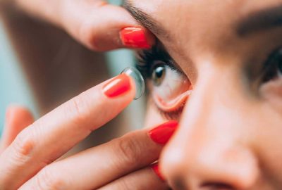 Person inserting a soft contact lens into their eye